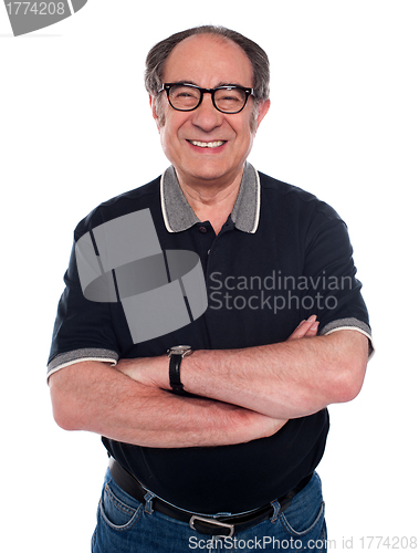 Image of Cheerful old man standing with arms crossed