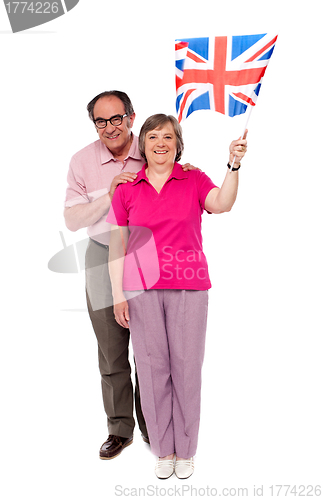 Image of Old couple waving UK flag. Supporting nation