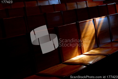 Image of Rows of church pews with stream of light