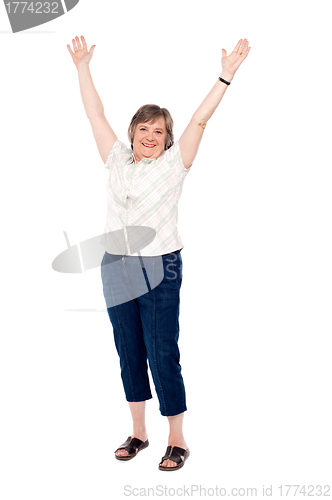 Image of Cheerful senior woman lifting her arms up