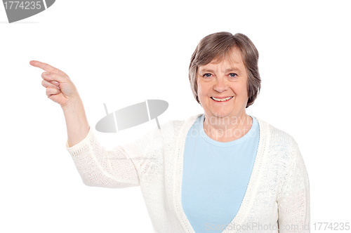 Image of Matured casual lady pointing at copy space
