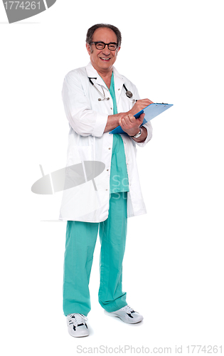 Image of Aged doctor holding clipboard. Full length shot