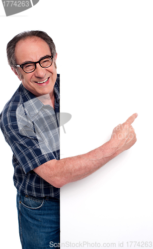 Image of Causal matured man pointing finger at placard