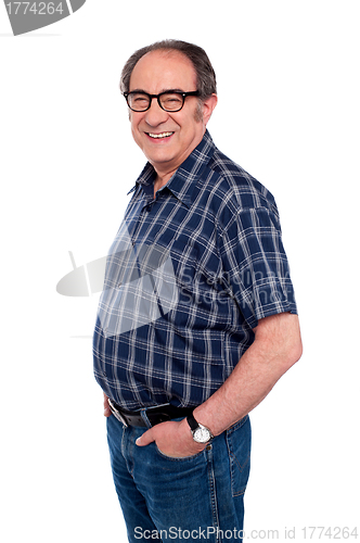 Image of Man standing with hands in jeans pocket