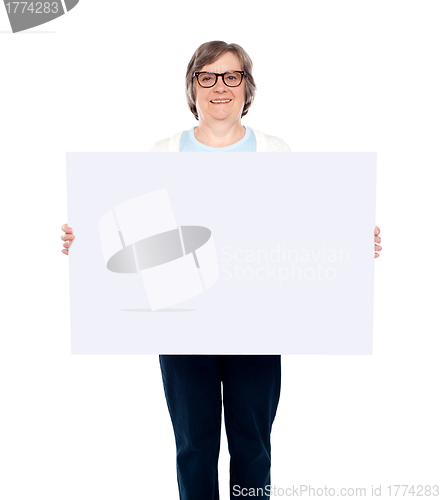 Image of Aged woman displaying blank poster