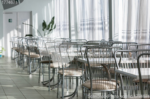 Image of Photo of a canteen with metal chairs and tables