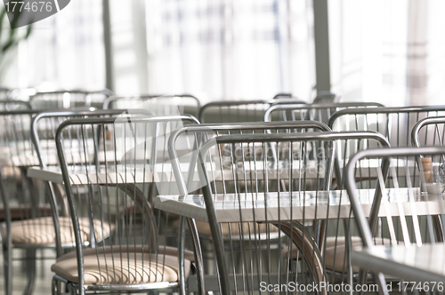 Image of Photo of a canteen with metal chairs and tables