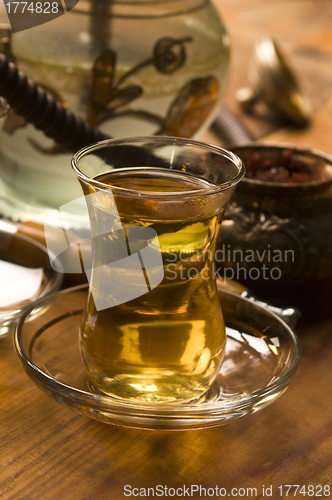 Image of Cup of turkish tea and hookah served in traditional style