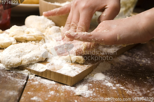 Image of Detail of hands kneading dough