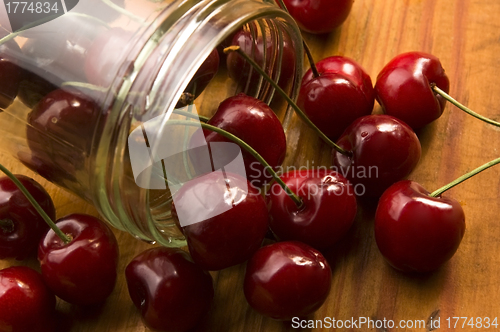 Image of Cherry in glass jar isolated on the wooden background