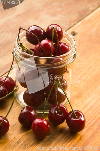 Image of Cherry in glass jar isolated on the wooden background