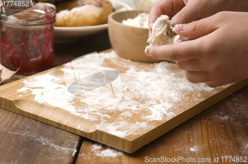 Image of Detail of hands kneading dough