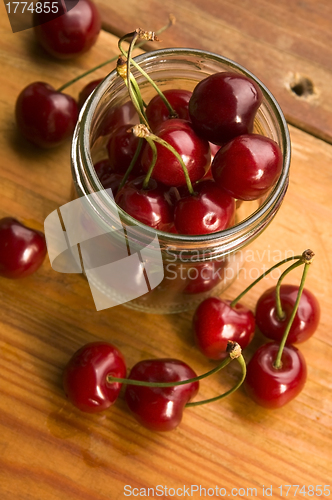 Image of Cherry in glass jar isolated on the wooden background