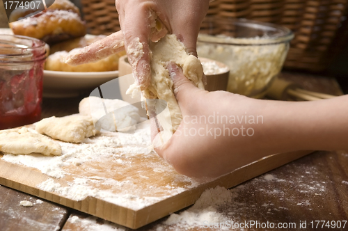 Image of Detail of hands kneading dough