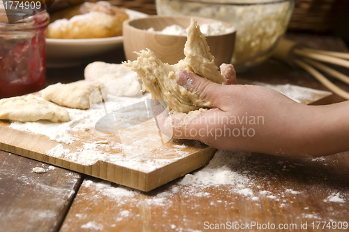 Image of Detail of hands kneading dough