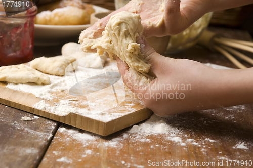 Image of Detail of hands kneading dough