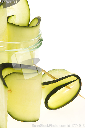 Image of Pile of sliced zucchini pieces arranged on white background