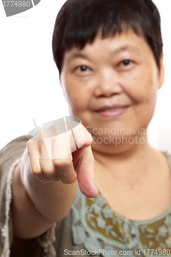 Image of Portrait of a happy senior woman pointing forwards on white. 