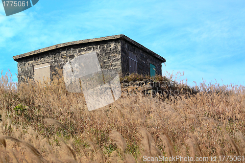 Image of old stone house with grass on the mountain 