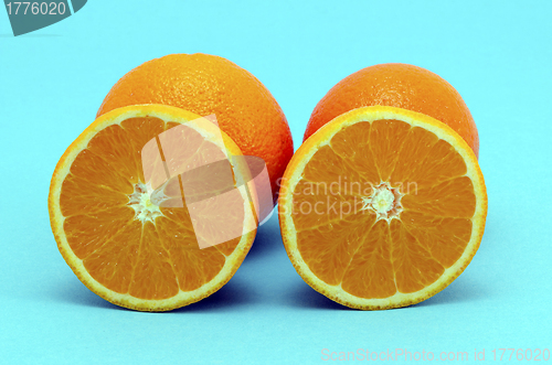 Image of Orange fruit full and sectioned on blue background 