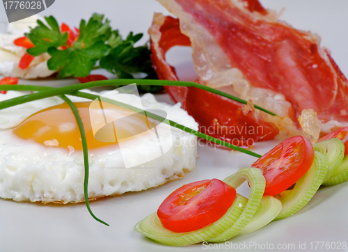 Image of Fried Eggs Sunny Side Up with greens and bacon