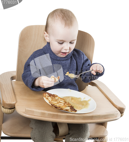 Image of young child eating in high chair