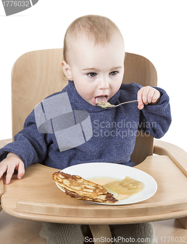 Image of young child eating in high chair