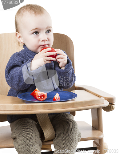 Image of young child eating in high chair