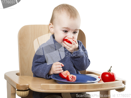 Image of young child eating in high chair