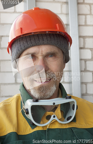 Image of An elderly worker in protective helmet
