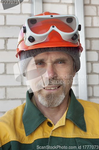 Image of An elderly worker in protective helmet