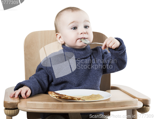 Image of young child eating in high chair