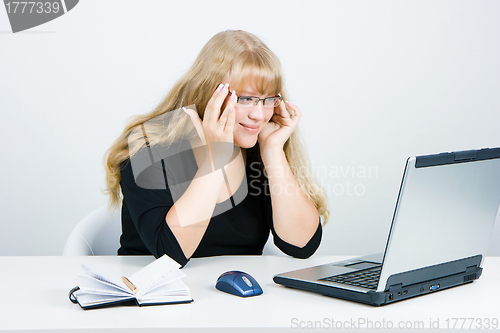 Image of Smiling blonde looks at the monitor