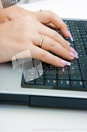 Image of Women's hands on the laptop keyboard