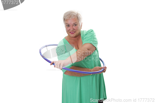 Image of Senior lady doing gymnastic with hula-hoop