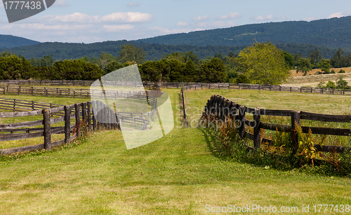 Image of Rolling meadows with wooden fences and hills