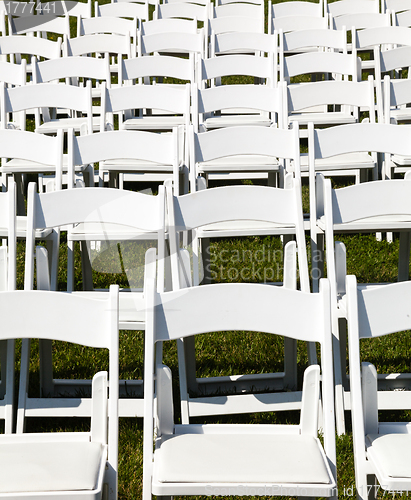 Image of Rows of wooden chairs set up for wedding