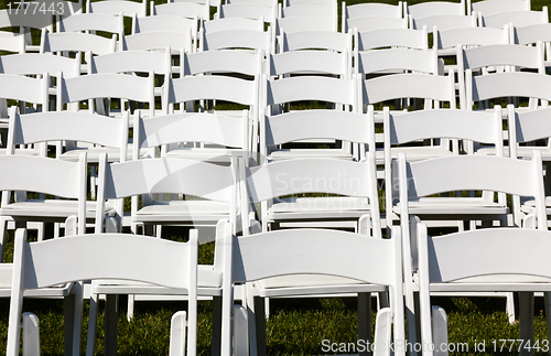 Image of Rows of wooden chairs set up for wedding