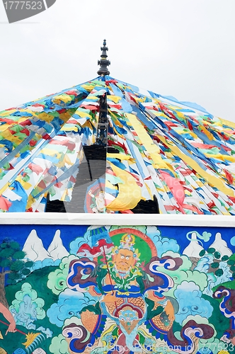 Image of Tibetan prayer flags and ancient wall art