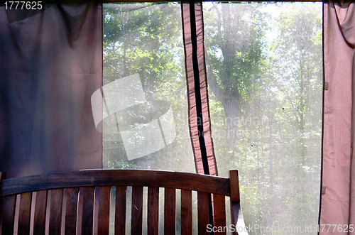 Image of Summerhouse bench and view through net to nature 