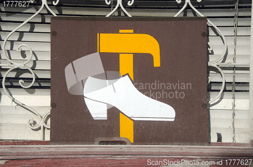 Image of Shoe repair shop sign on window. hammer and shoe 