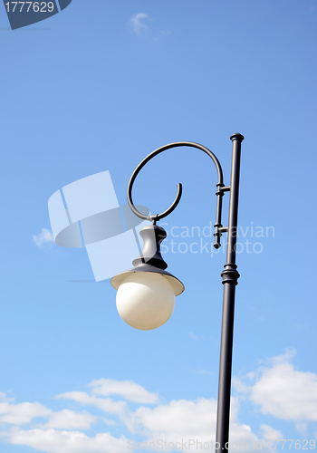 Image of Park round light lamp on pole on background of sky 