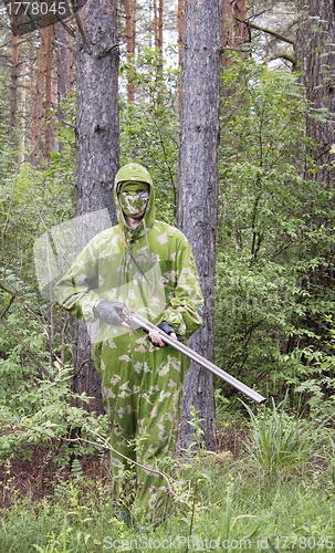 Image of The shooter in camouflage in the forest