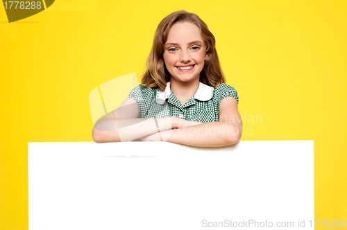 Image of Girl posing behind an advertising board