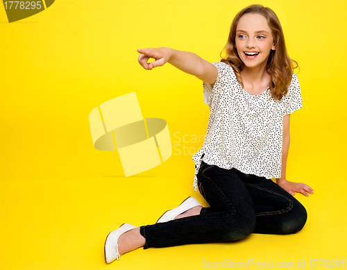 Image of Smiling young girl pointing away