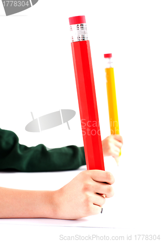 Image of Two girls hands holding big pencil. Closeup