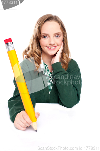 Image of Young girl using an over sized pencil