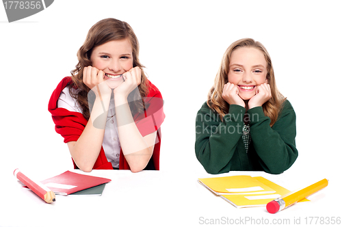 Image of Happy young girls sitting at desk