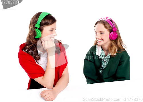 Image of Pretty girls enjoying music. Looking at each other