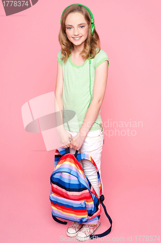 Image of Young girl with schoolbag posing in studio